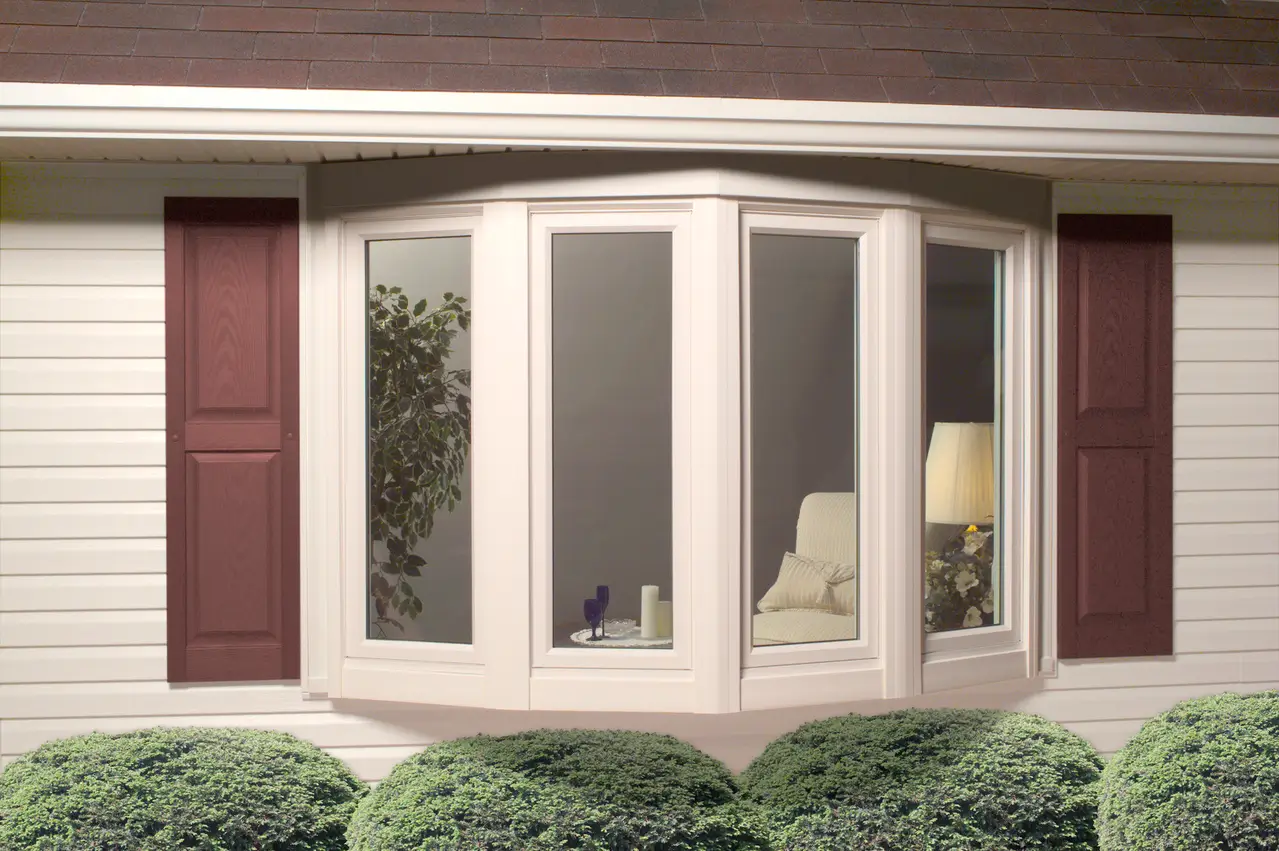 A Window with wooden shutters and white trim, showcasing a classic architectural design.