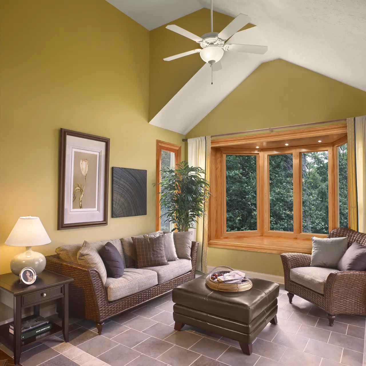 Bright living room with yellow walls, a ceiling fan, and Windows that enhance the airy atmosphere.