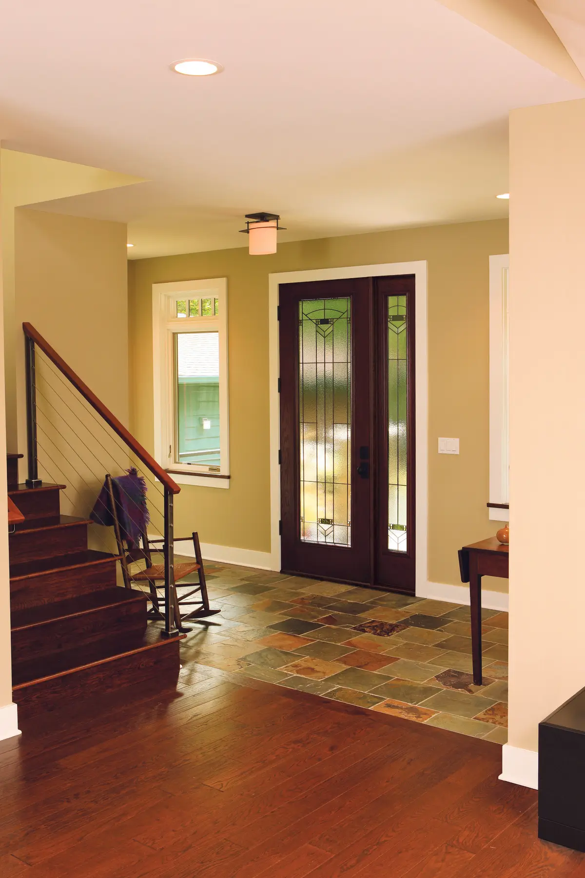 A cozy living room with a wooden floor and a staircase, creating a welcoming and stylish environment.