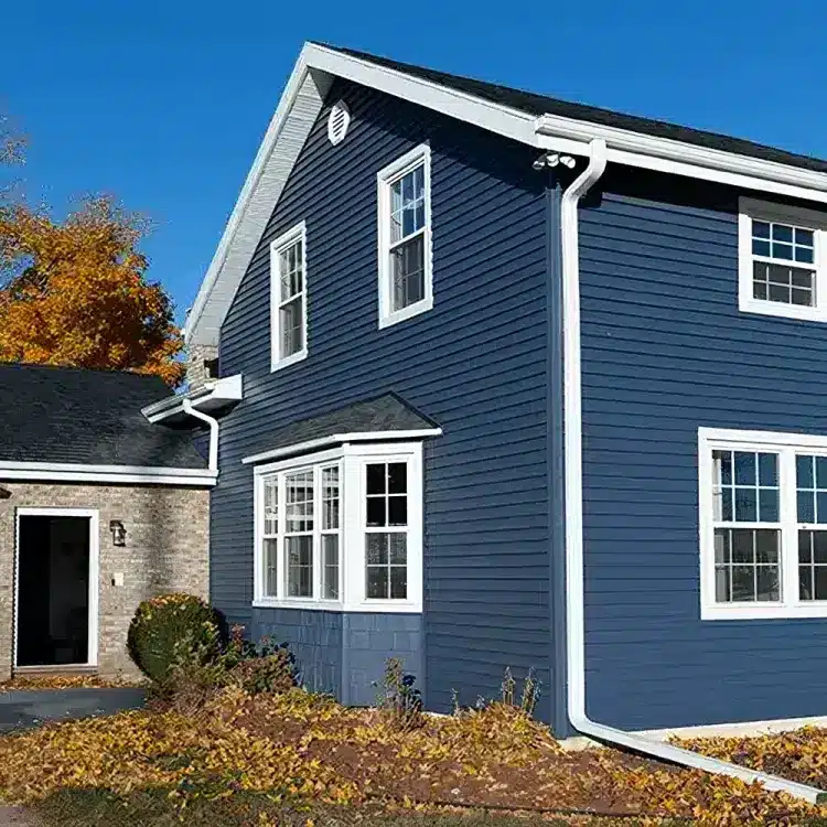 A cozy blue house featuring white trim and siding, creating a cheerful and welcoming appearance.