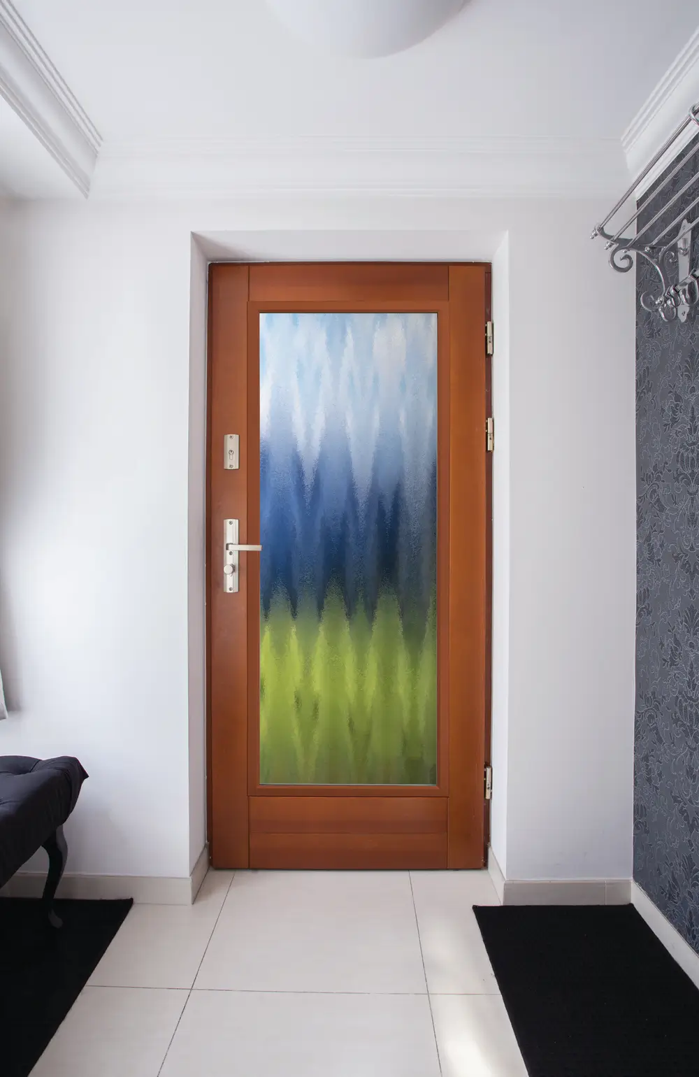 A colorful patterned Door stands in a bright white room, adding a vibrant touch to the minimalist space.