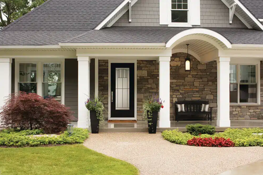 House exterior with black front door, stone walls, and white trim