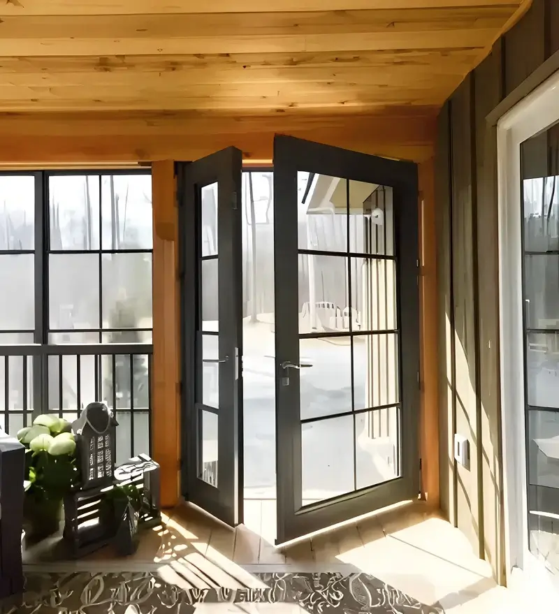 A welcoming porch with WeatherMaster™ Doors and comfortable wicker chairs, perfect for enjoying the outdoors.
