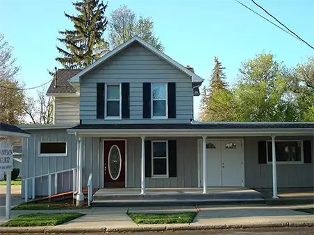 House with gray vinyl siding, white trim, and black shutters